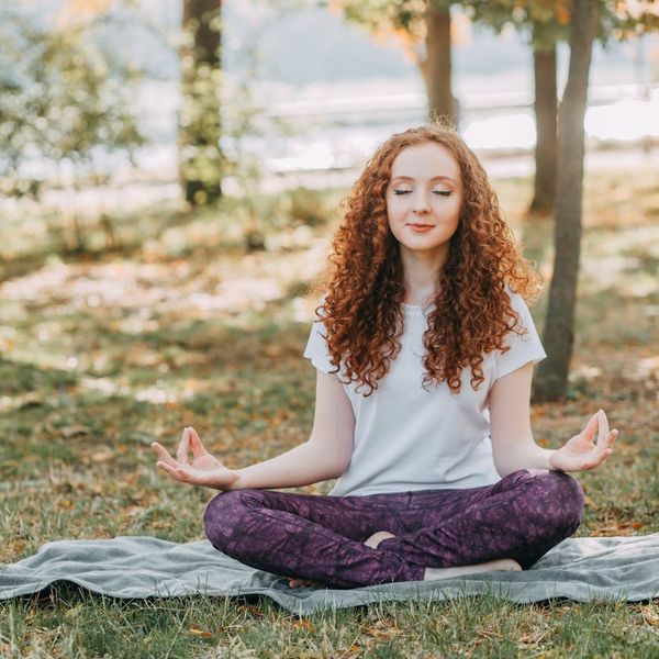 Person meditating peacefully in a calm, natural setting.
